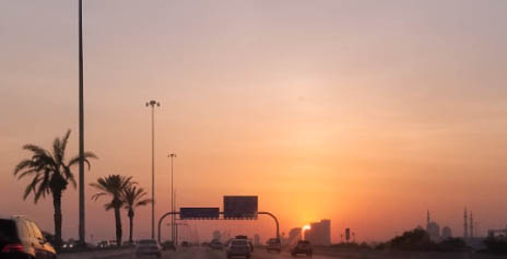 How To Visit Abu Dhabi's Grand Mosque During A 3-Hour Layover 3 Witnessing a warm sunset from the car with the Grand Mosque in the background during a 3-hour layover in Abu Dhabi.