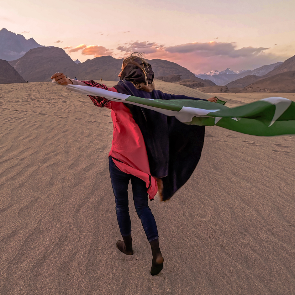 A Complete Travel Guide To Skardu, Pakistan 14 Foreign girl with a Pakistani flag at Katpana Cold Desert near Skardu, Pakistan.