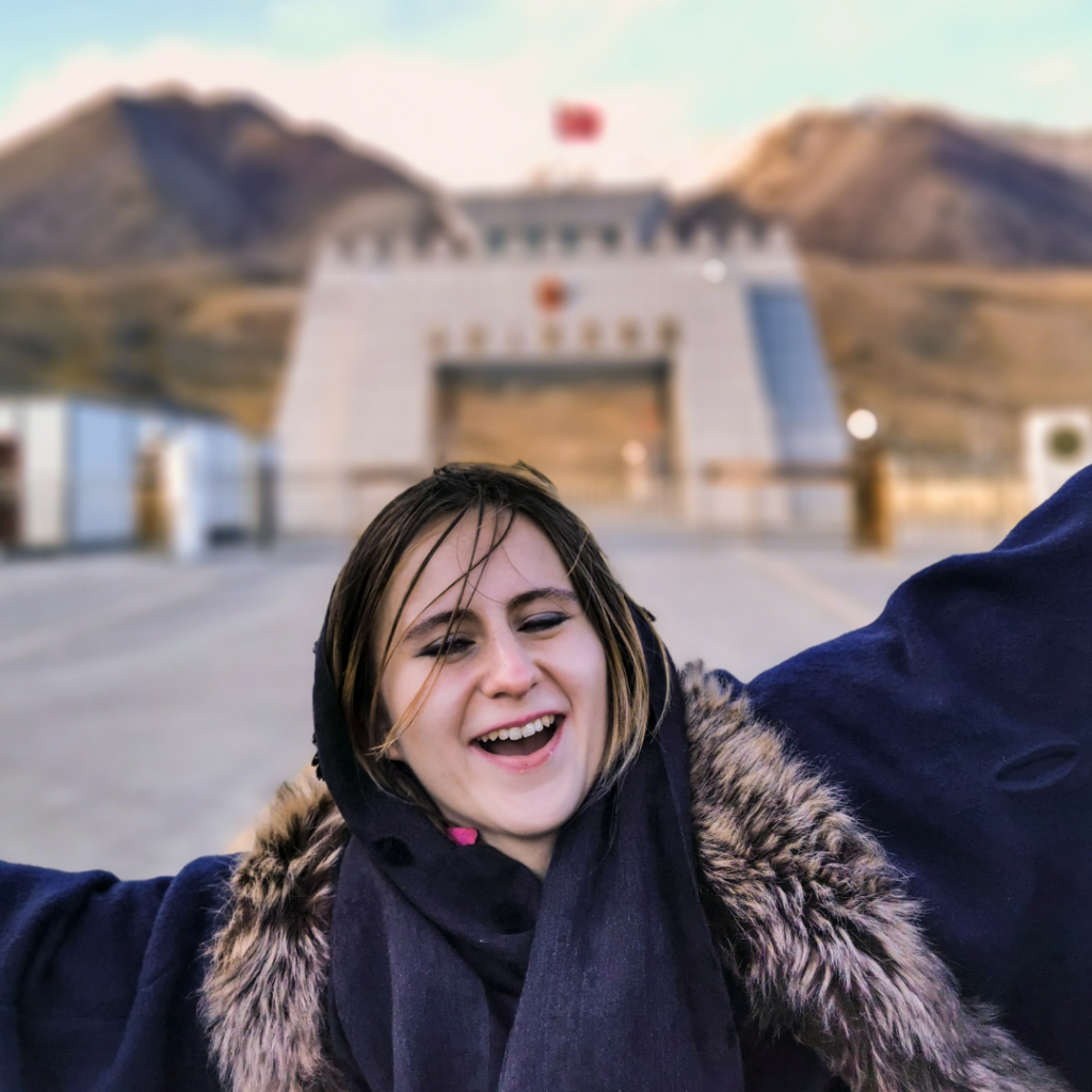Warm Encounters At The Icy Border: Visiting Khunjerab Pass From Hunza Valley 11 Foreign girl making funny faces in front of the Pakistan-China border at Khunjerab Pass.