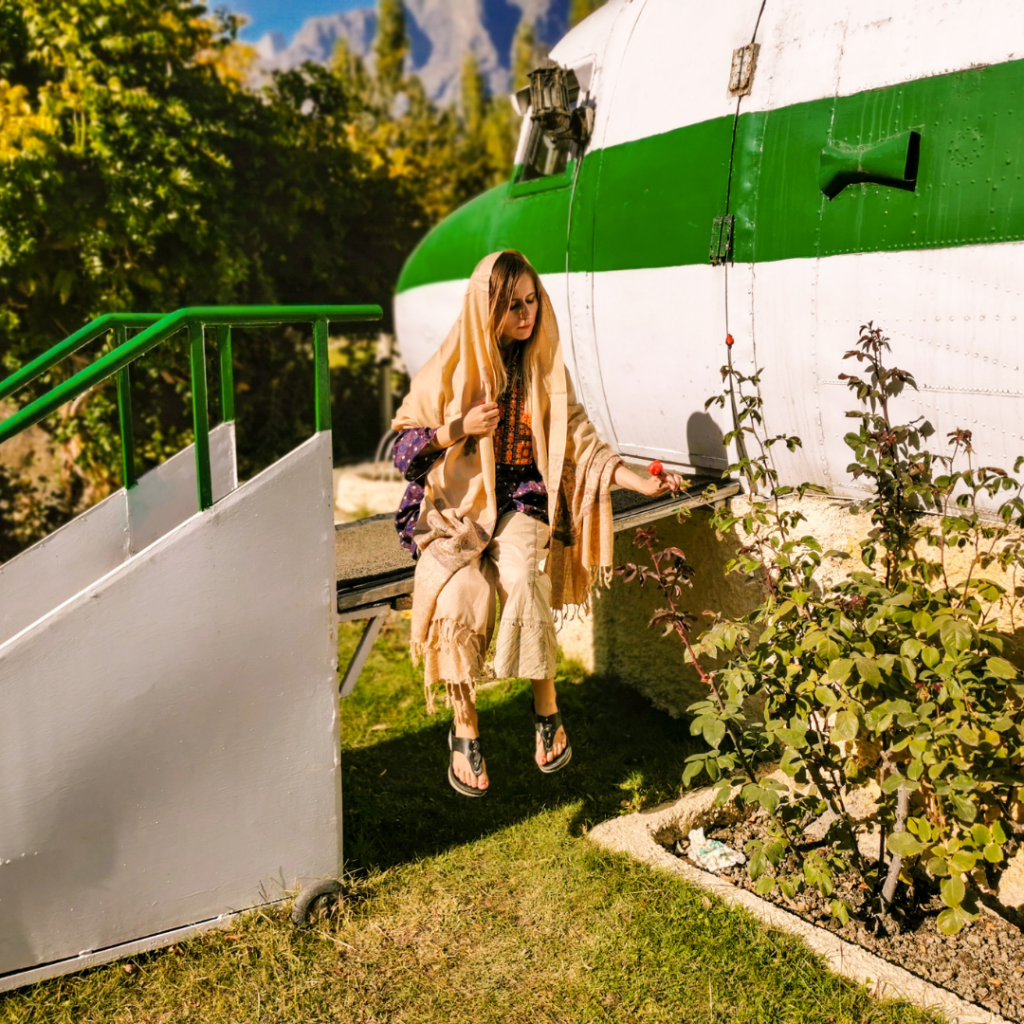 A Complete Travel Guide To Skardu, Pakistan 8 Foreign girl sitting in front of an airplane wreck at Shangrila Resort in Skardu, Pakistan.