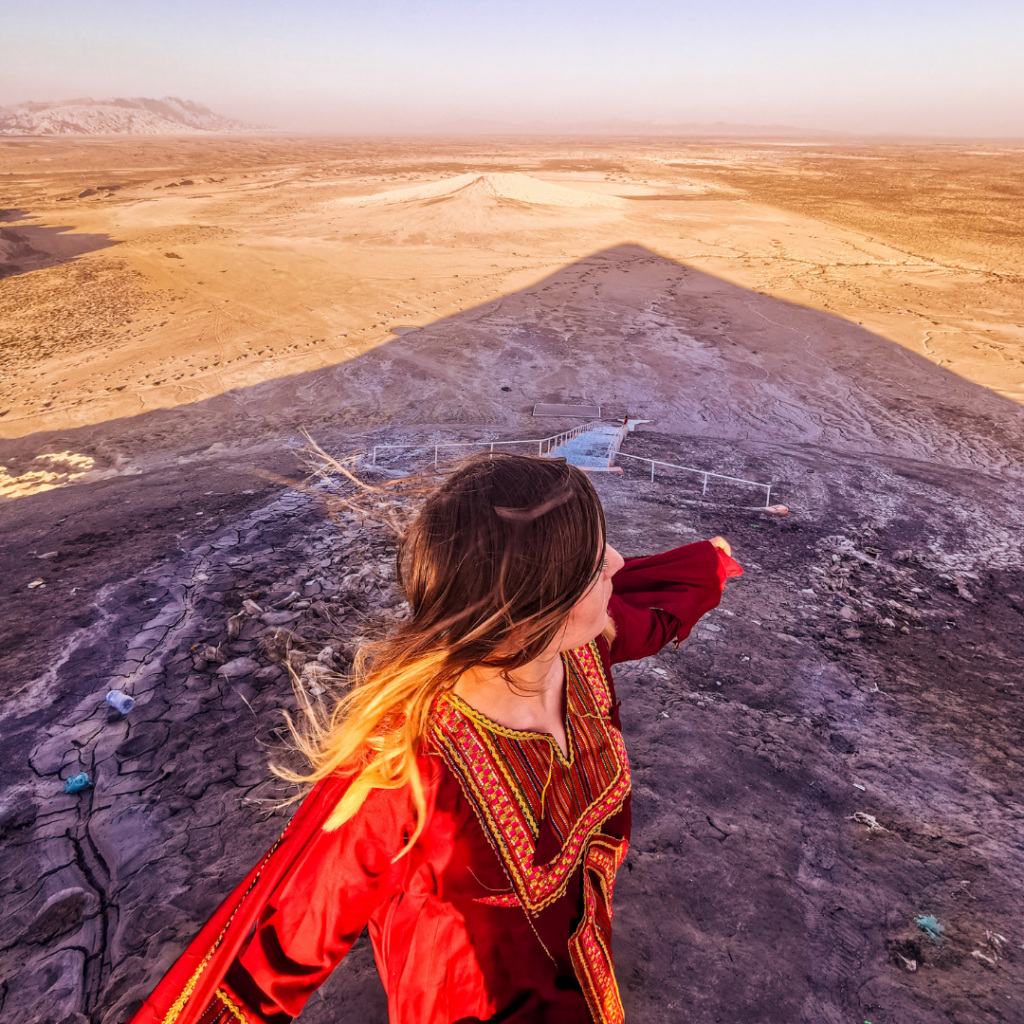 Full Itinerary For An Incredible Balochistan Day Trip From Karachi 15 Girl standing on top of Chandragup mud volcano in Hingol National Park, Balochistan, Pakistan, during sunset.