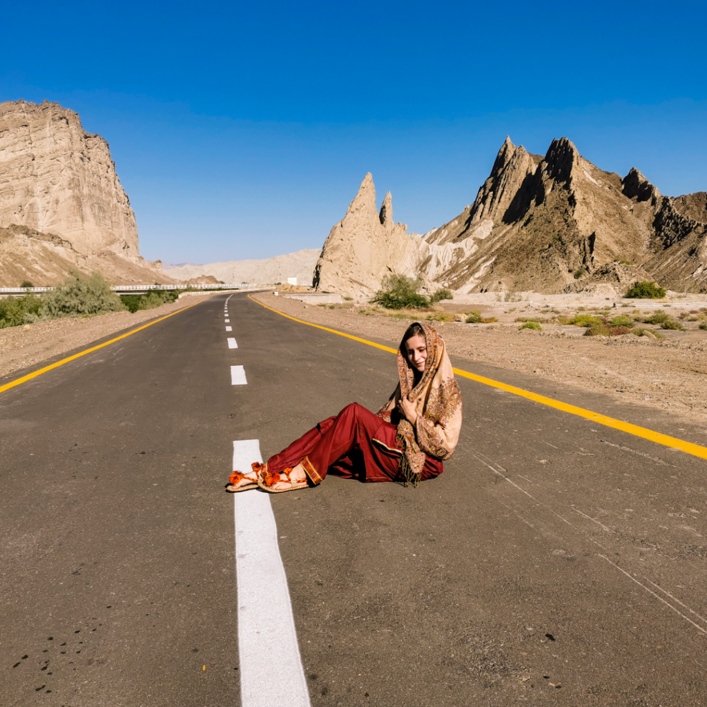 Full Itinerary For An Incredible Balochistan Day Trip From Karachi 17 Girl sitting in the middle of Makran Coastal Highway in Hingol National Park, Balochistan, Pakistan.