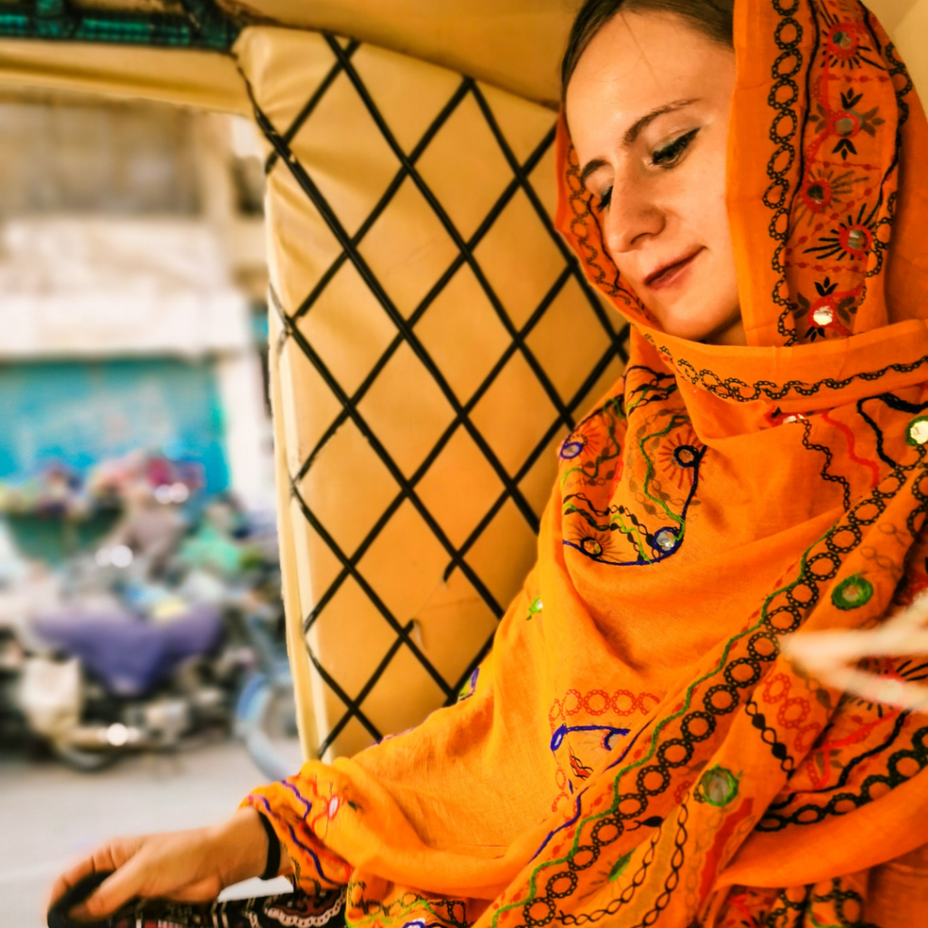 Foreign girl in Sindhi dressing sitting in a rickshaw in Karachi, Pakistan.