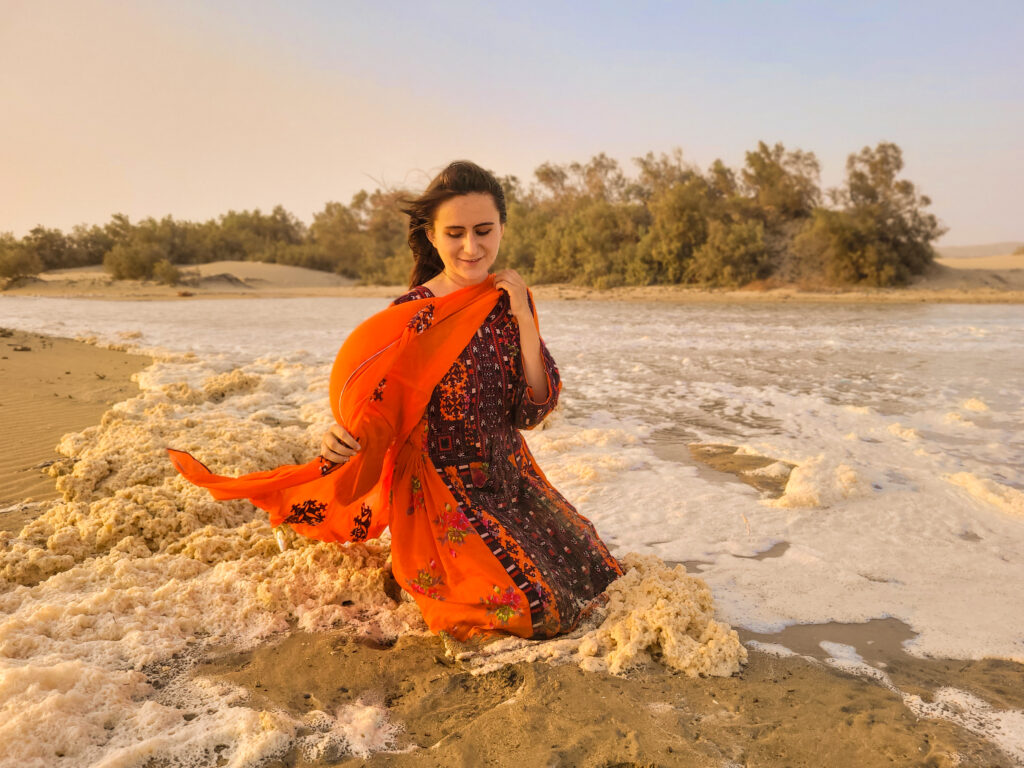 20 Stunning Places To Visit In Chabahar, Iran 25 Tourist girl in traditional Balochi dress sitting between foam and waves at Darak Beach, Balochistan, Iran.
