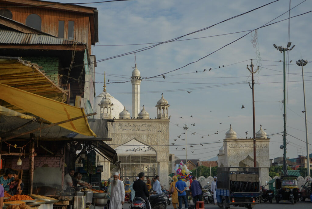 A crowd passing through a busy market in front of Hazratbal Shrine in Srinagar, Kashmir